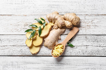 Composition with fresh ginger on light wooden background