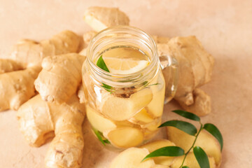 Fresh ginger and mason jar of tasty beverage on table
