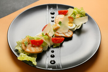 Plate with tasty Caesar salad on color background, closeup