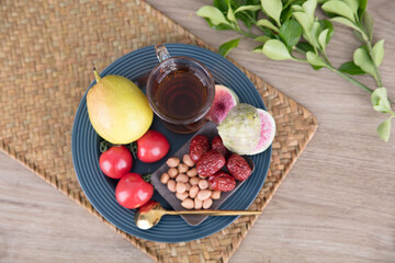 A cup of black tea and various tea snacks on the plate