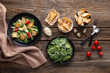 Composition with tasty Caesar salad and sauce on wooden background