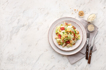 Plate with tasty Caesar salad and sauce on light background