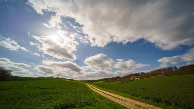Timelapse white clouds a green field. Summer sunny day nature time lapse
