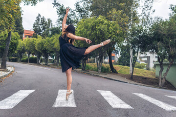 Ballet dancer performing graceful figure dance on one leg with pointe shoes