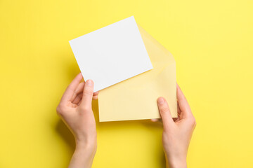 Female hands with blank sheet of paper and envelope on color background