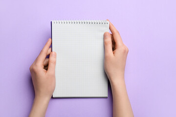 Obraz premium Woman holding blank notebook on color background, closeup