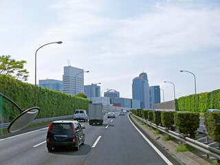 Driving by Tokyo highway with tall green Overgrown noise barriers with grass on roadsides, Japan