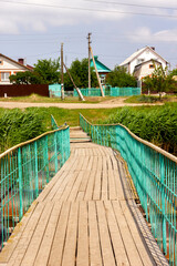 floating wooden bridge on pantons across the river in summer