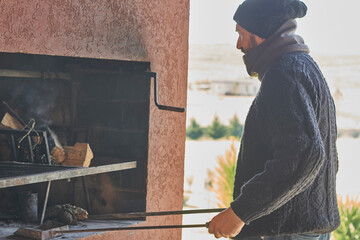 Hombre preparando el fuego para un asado