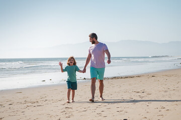 Father and son walking on sea. Dad and child holding hands and walk together.