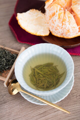 Brewed green tea and a peeled orange