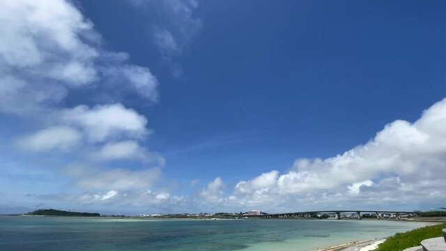 OKINAWA, JAPAN - JUNE 2021 : View of Senaga island and beach (Ocean or sea). Clear blue summer sky, clouds and air plane. Wide view real time shot in daytime. Holiday, vacation and resort concept.