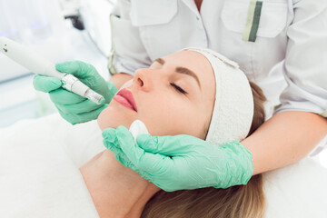 young beautiful woman in the cosmetologist’s clinic fractional mesotherapy for her face