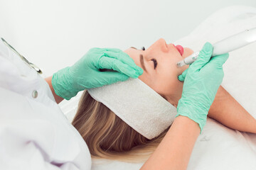 young beautiful woman in the cosmetologist’s clinic fractional mesotherapy for her face