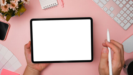 Top view creative woman holding stylus pen and digital tablet with empty screen.