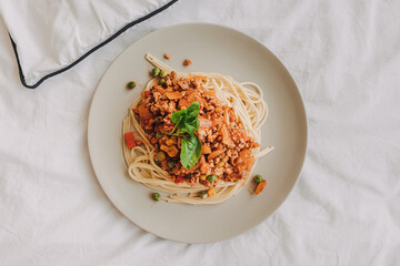 Homemade Spaghetti sauce with ground pork served in white dish.
