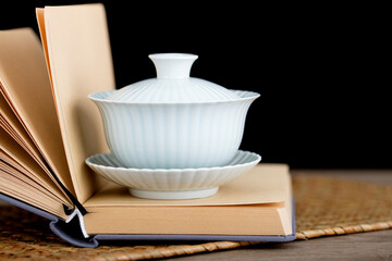 An open blank book with tea on a tureen