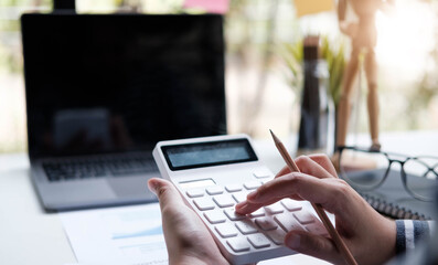 woman working with calculator, business document and laptop computer notebook
