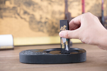 Grind the ink in the inkstone with the ink stick in hand