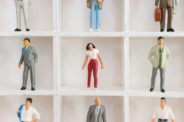 Miniature woman and a group of miniature men. concept of gender discrimination