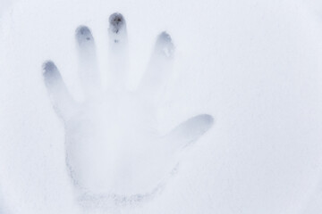 Handprint of a man in the snow. Low contrast image. Shallow depth of field.