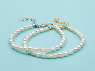 Luxury elegant baroque pearl bracelets on bright turquoise textured background