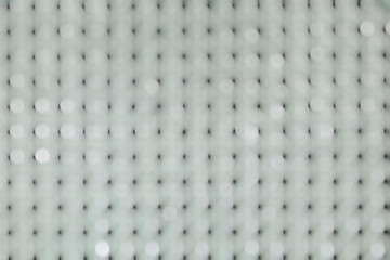 Abstract white bokeh on a white background with rows of black dots.