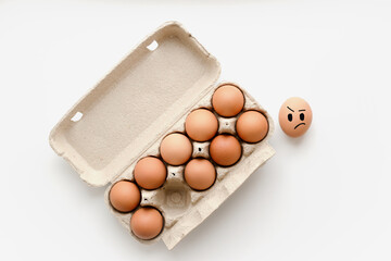 A paper box with a dozen raw eggs on a white background, one empty cell without an egg, the egg...