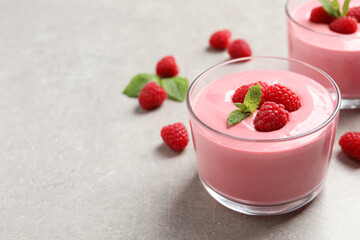 Delicious raspberry mousse with mint on light grey table, space for text