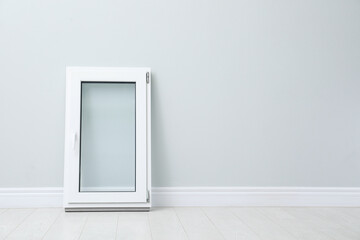 Modern single casement window near light grey wall indoors, space for text