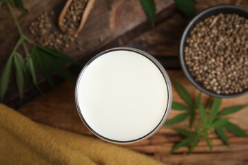 Obraz na płótnie Canvas Glass of fresh hemp milk on wooden table, top view