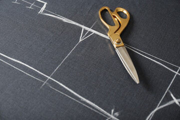 Scissors on grey fabric with chalked sewing pattern