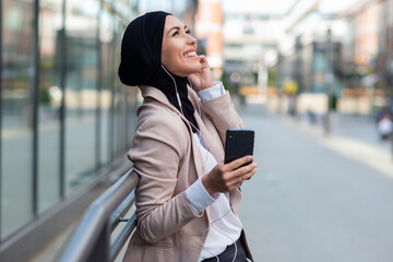 Arabic business woman listening to music outside