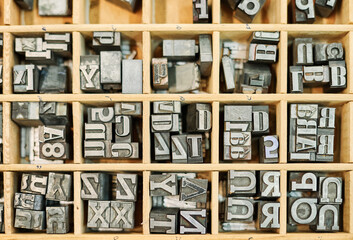 Collection of metal letters in wooden box