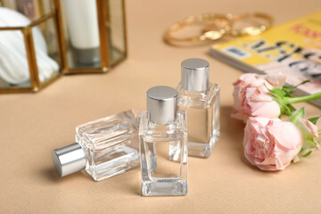 Perfumes and rose flowers on beige table
