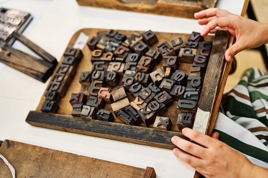Crop craftsman working with letterpress letters in workshop