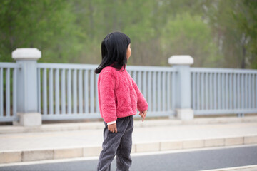A five-year-old Chinese girl turns her head and looks into the distance