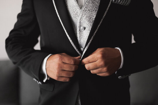 Elegant bridegroom buttoning wedding suit