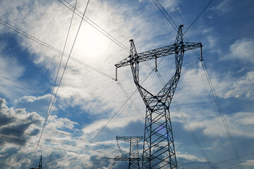 High-voltage electric lines, towers and industrial infrastructure against the blue sky