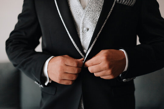 Elegant bridegroom buttoning wedding suit