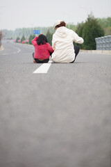 Mom and daughter sit in the middle of the road and shoot back