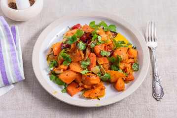 Vegetarian dish - baked sweet potato with parsley in a plate close-up