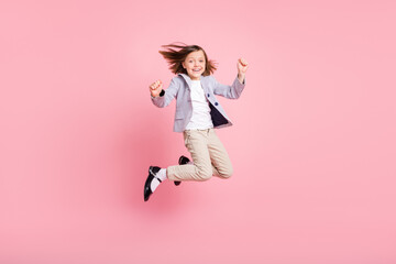 Full body photo of hooray small girl jump wear blazer trousers shoes isolated on pastel pink color...