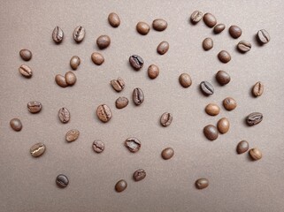 Fototapeta na wymiar Coffee beans on a brown background, pattern. Coffee varieties, roasting, coffee making. The backdrop.