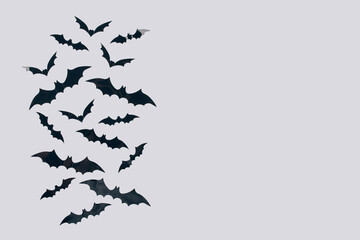Halloween background - decorative paper bats on light gray background with copy space. Halloween decorations or party invitation concept. Selective focus