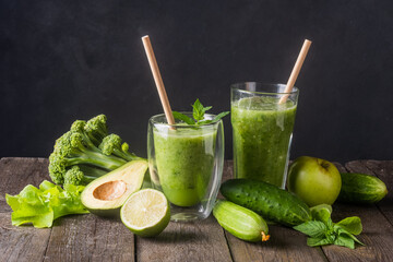 Fresh green smoothie in glass on wooden table, closeup.  Detox diet concept: green vegetables on rustic table. Clean eating, alkaline diet, weight loss food concept.