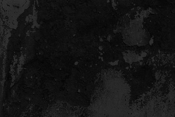 Old cement wall painted black, peeling paint texture and background