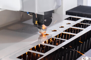 Automatic cnc laser cutting machine working with sheet metal with sparks at factory, plant....