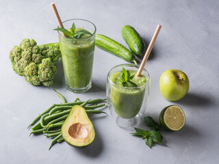 Fresh green smoothie in glass on wooden table, closeup.  Detox diet concept: green vegetables on rustic table. Clean eating, alkaline diet, weight loss food concept.