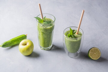 Fototapeta premium Fresh green smoothie in glass on wooden table, closeup. Detox diet concept: green vegetables on rustic table. Clean eating, alkaline diet, weight loss food concept.
